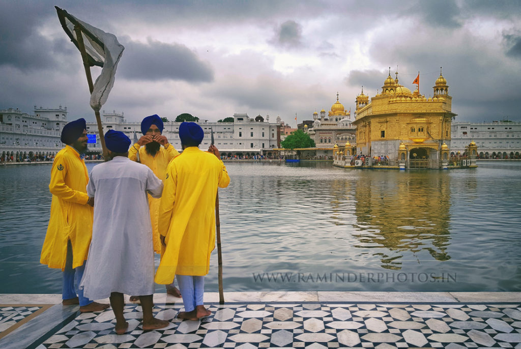 Monsoon clouds and sewadar service men light mood Golden Temple Amritsar