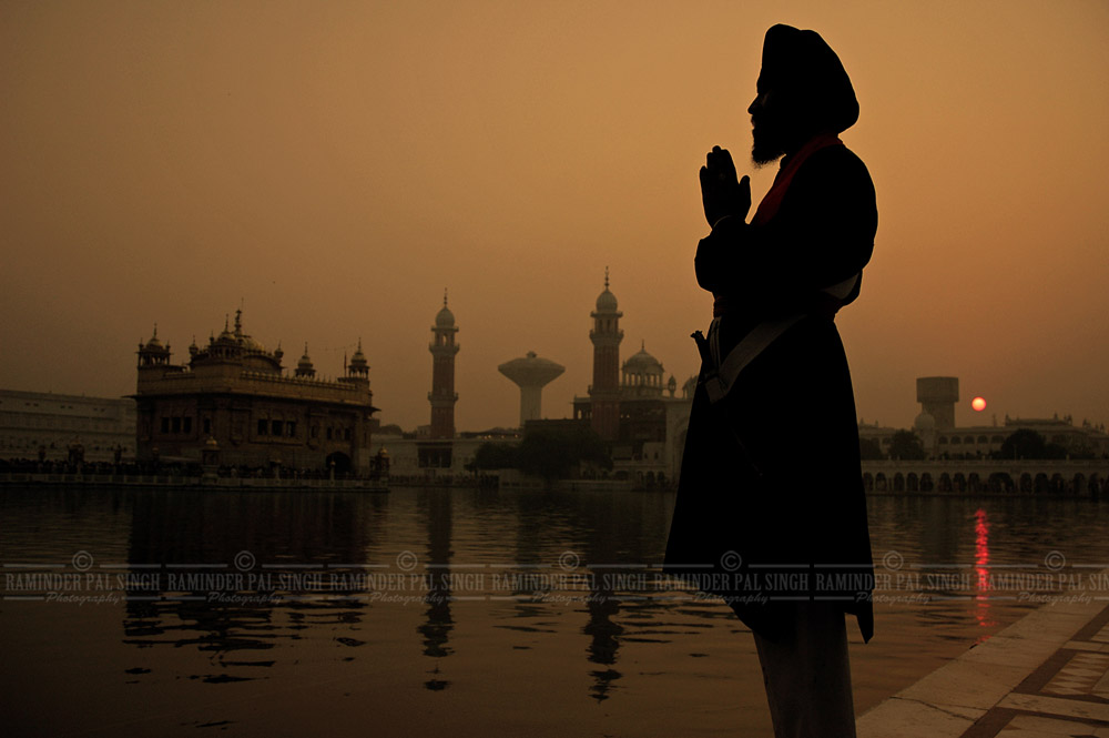 Silhouette of man prays early morning at sunrise at Golden Temple Amritsar