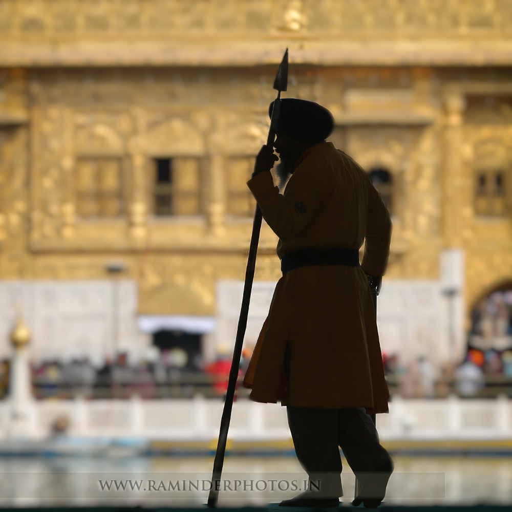 Holy guard service man with spear at entrance of Golden Temple