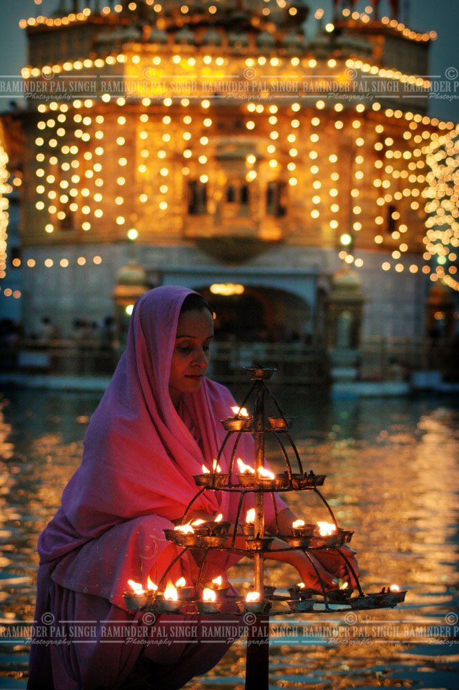 WOman lights lamps Golden Temple Amritsar Punjab