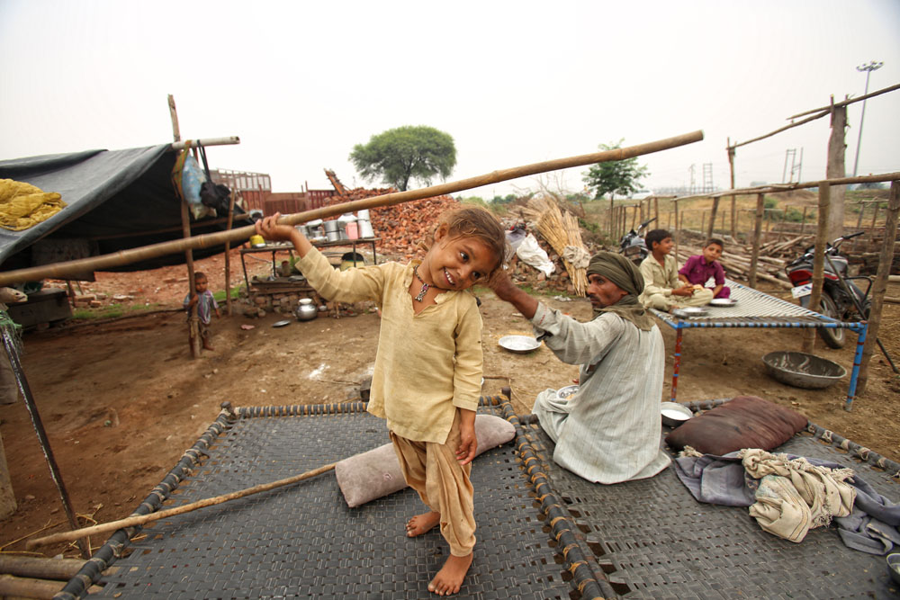 A nomadic tribal girl plays near her shanty