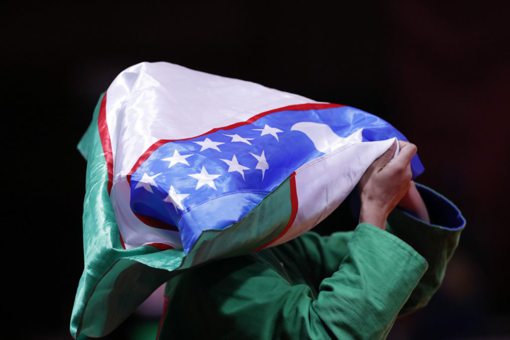 Usbekistan Kurash player reacts after winning gold with country flag over her head