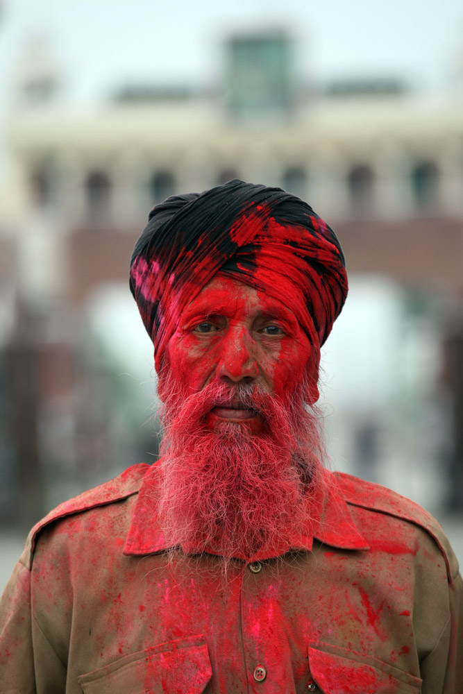 A Sikh worker is smeared in color by Indian Border Security Force (BSF) soldiers (unseen), during the Holi festival celebrations at the India-Pakistan, Joint Check Post (JCP) at the Attari border, some 30 kms from Amritsar, India, 17 March 2014. Holi is celebrated at the end of the winter season on the last full moon day of the lunar month Phalguna (February or March) which usually falls in the later part of February or March and main day is celebrated by people throwing colored powder and colored water at each other.