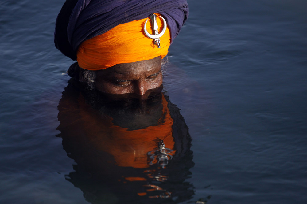 A Sikh devotee takes a holy dip in the sacred pond of the Golden Temple, the holiest of Sikh shrines on the occasion of the birth anniversary of the third Guru or the Master of the Sikhs, Sri Guru Amar Das Ji in Amritsar, India, 23 May 2013. Born in 1479, Guru Ram Das Ji also fought the caste system and preached in favour of women's rights.