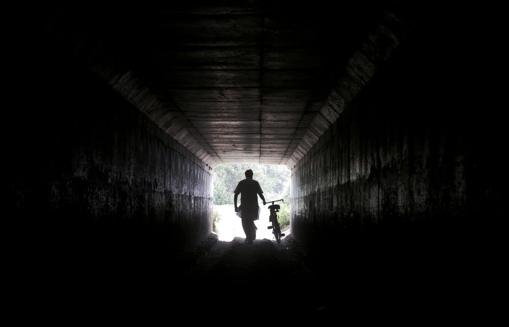 A man goes through a tunnel with his cycle at a village in Amritsar