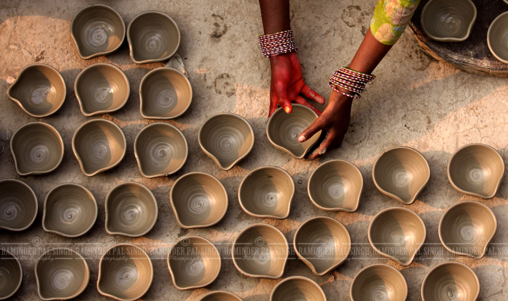 a potter makes earthen traditional lamps for Diwali festival