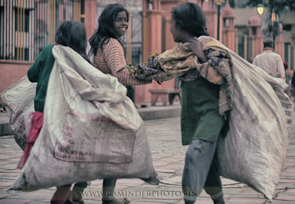slum girls share smiles as they meet in a street