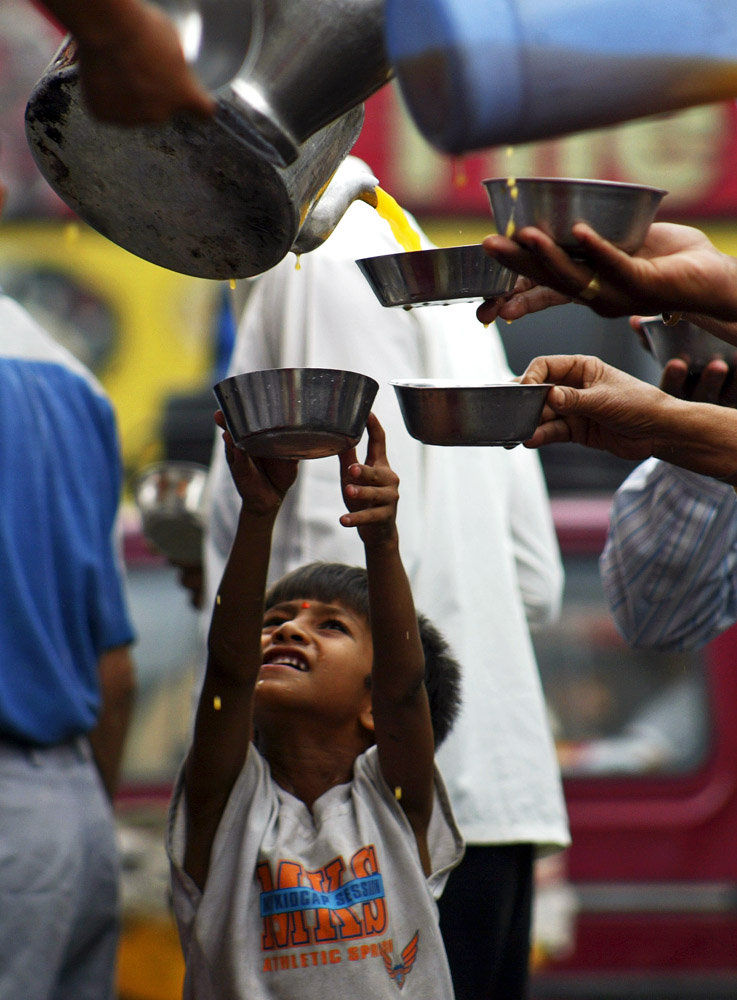 a kid waits to get sweetened water on a hot day