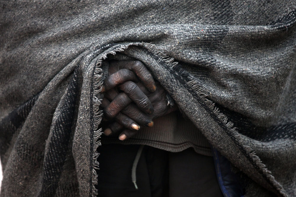 labourer hands wrapped in a blanket on a cold morning