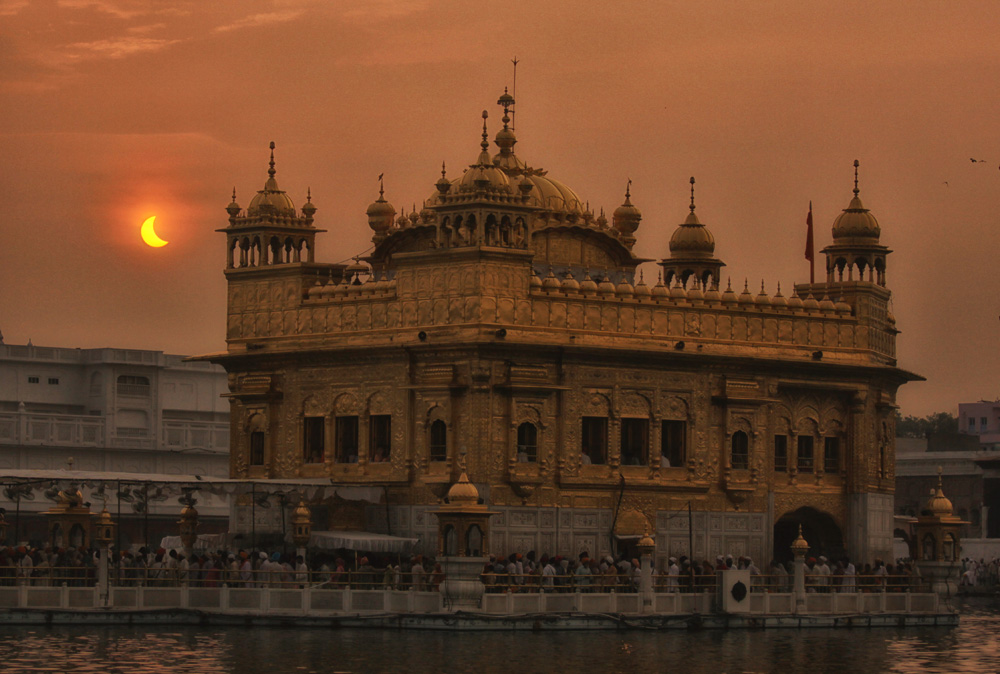 partial solar eclipse morning view of the Golden Temple the most sacred place for Sikhs