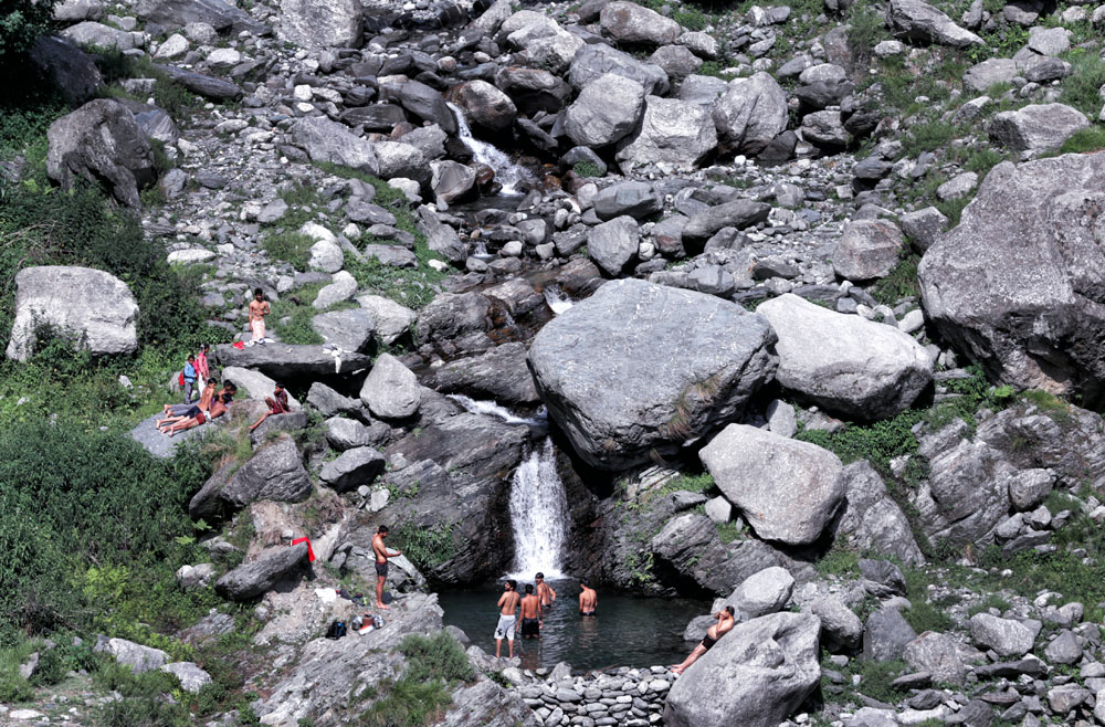 people cool off in a waterfall in remote location in Himachal Pradesh